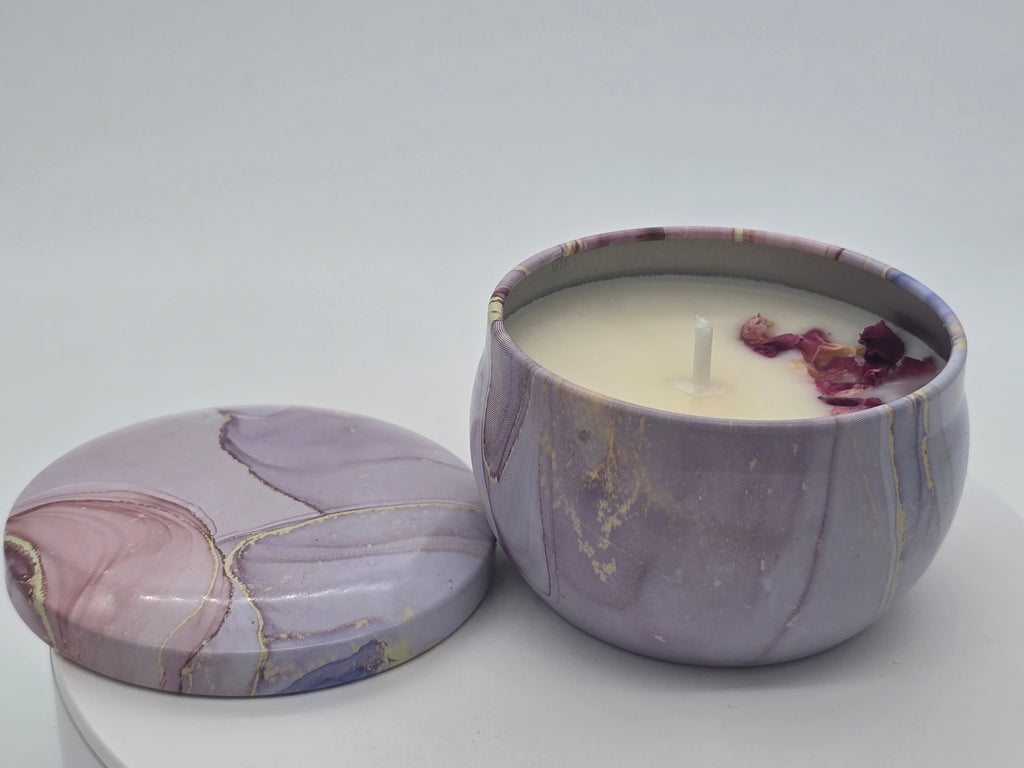 Marbled purple container with a lit candle inside on a white background