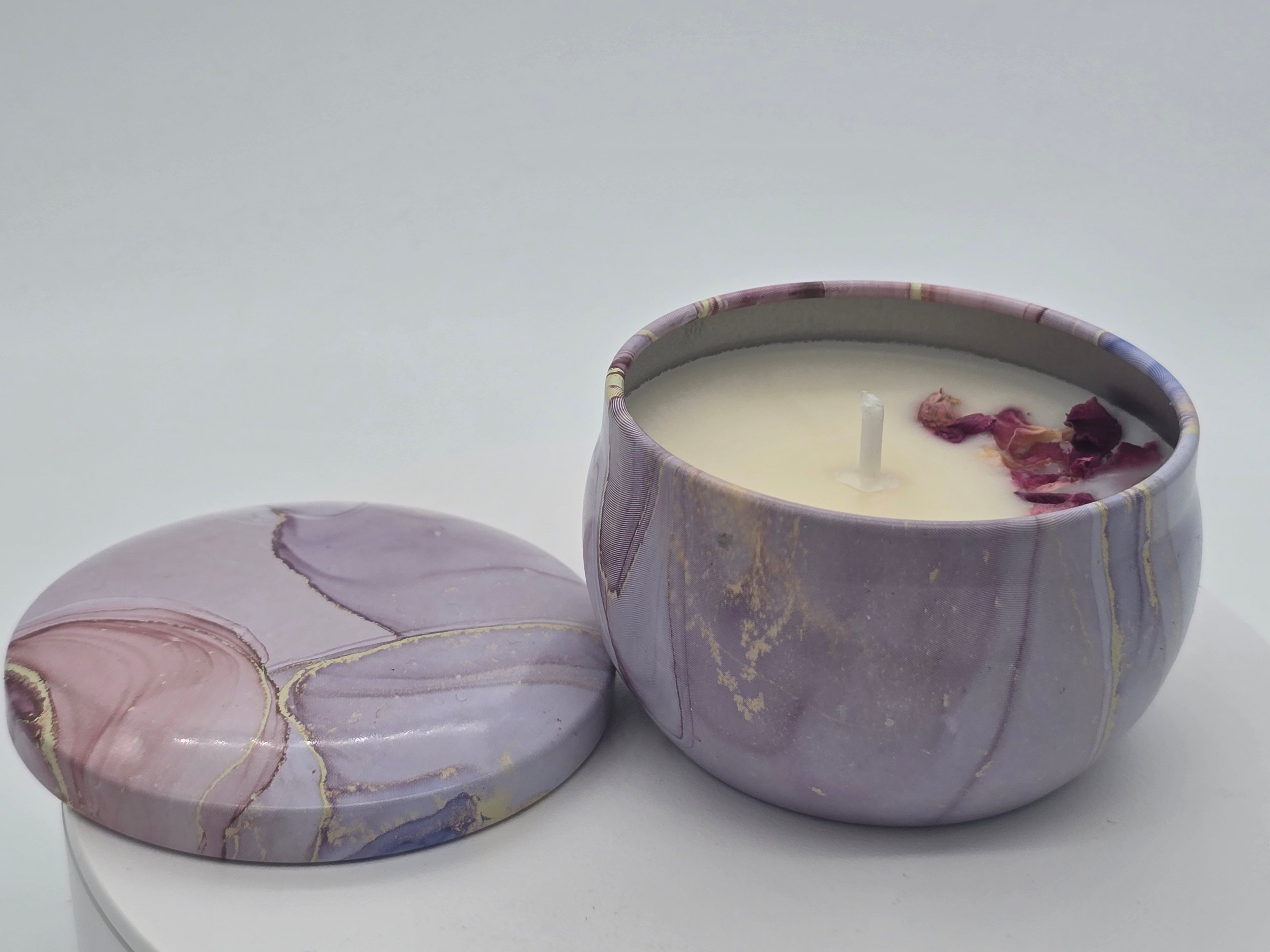 Marbled purple container with a lit candle inside on a white background