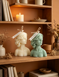 Intricately sculpted with a delicate floral blindfold woven across her gaze, soft curled hair, and a graceful neck silhouette, this hand-poured candle carries an air of serene calm and poetic mystique.